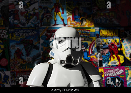 Madrid, Espagne - 30 novembre 2014 : Head shot of a white Imperial Stormtrooper action figure contre un mur coloré, couvert de vieux Marvel comics. Banque D'Images