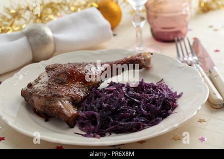 L'oie rôtie avec du chou rouge braisé à la jambe sur une table de Noël Banque D'Images