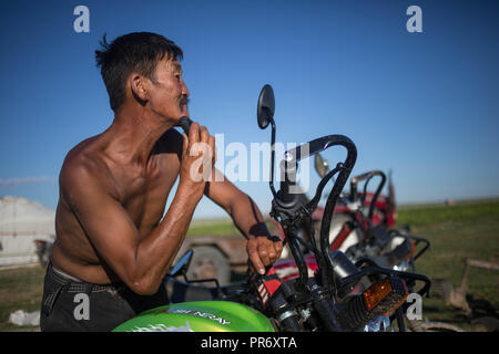 Un homme vu de sa barbe aidé par le miroir moto près de la ville de dans la province de Bayangol Övörkhangai, sud de la Mongolie. Banque D'Images