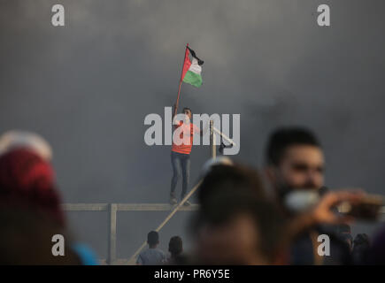 Un manifestant palestinien criant du pavillon, tels qu'ils se présentent à l'Israel-Gaza clôture frontalière au cours des affrontements. 7 Palestiniens, dont un jeune de 14 ans tué par des tirs israéliens lors d'un nouveau choc à la frontière de Gaza, le ministère de la santé du Hamas dans la bande de contrôle. Banque D'Images