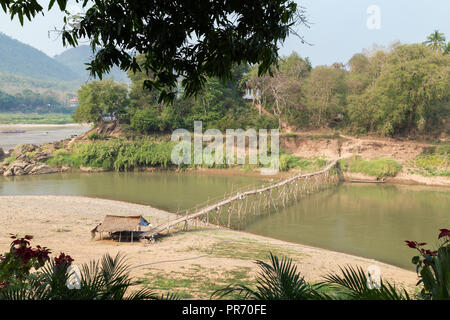 Vue d'un pont de bambou sur la rivière Nam Khan à marée basse et d'une berge à Luang Prabang, Laos, lors d'une journée ensoleillée. Banque D'Images