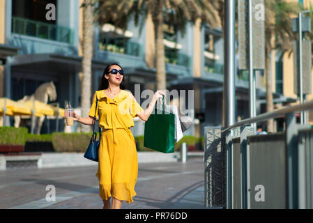 Asian girl with shopping bags et café à l'extérieur Banque D'Images