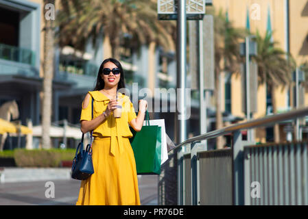 Asian girl with shopping bags et café à l'extérieur Banque D'Images