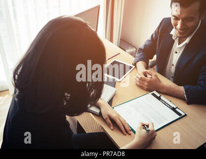 Superviseur sourit entre un travailleur féminin d'entrevue d'emploi Banque D'Images