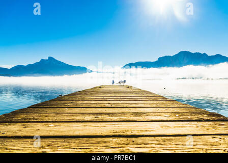 Vue sur Foggy Mountain paysage avec les mouettes sur la jetée du lac de Mondsee en Autriche Banque D'Images