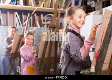 Smiling ecolières avec plaisir de tirer une leçon de l'atelier créatif Banque D'Images