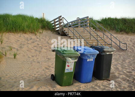 Recycler les déchets organiques, et l'élimination des récipients, dans trois couleurs vert, bleu et noir sur une plage de sable rouge, enrance, Parc National de Greenwich, l'Î. Canada Banque D'Images