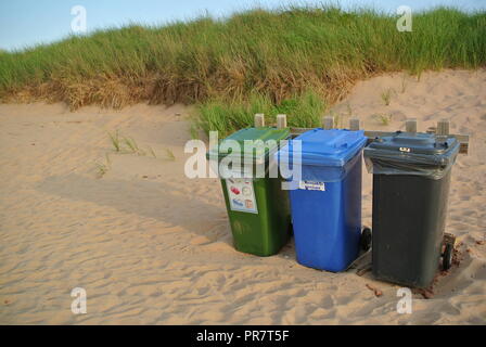 Recycler les déchets organiques, et l'élimination des récipients, dans trois couleurs vert, bleu et noir sur une plage de sable rouge, à Greenwich, parc national de l'Î. Canada Banque D'Images