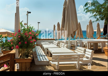 Tables et bancs blanc contre la mer Banque D'Images