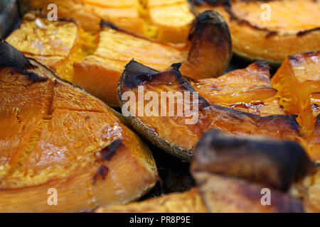 Tranche de potiron bio cuits pour Halloween de cette année. Au fond coloré de squash. Potiron grillé sucré avec du miel pour l'Halloween et Thanksgiving Banque D'Images