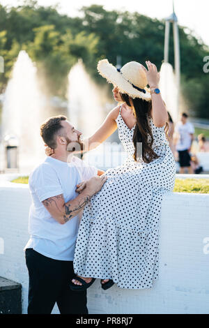 Beau barbu et sa belle fille se reposant près des fontaines Banque D'Images