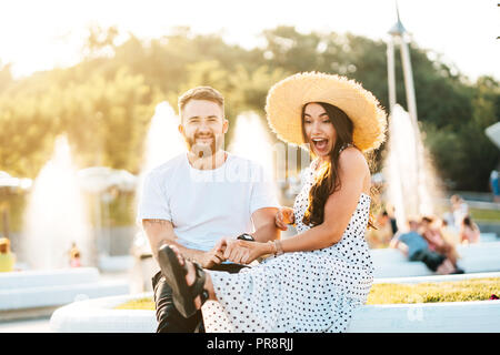 Beau barbu et sa belle fille se reposant près des fontaines Banque D'Images