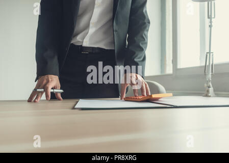 Portrait dans son bureau Bureau de la paperasserie dans open binder faisant un rapide calcul sur calculatrice. Banque D'Images