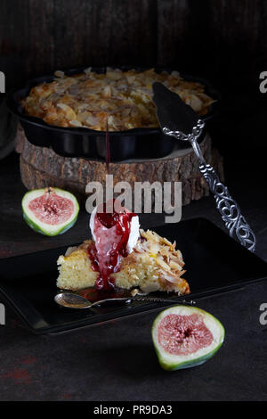 Tarte aux figues flocons d'amandes et de crème glacée à la vanille, avec des gouttes de sauce. Banque D'Images