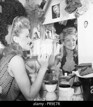 Ballerine dans le 1940s. La jeune fille de théâtre se prépare pour la performance de tonights et est assise devant le miroir, finissant avec son maquillage. Des cosmétiques de différents types se trouvent sur la table. Elle a mis des photos d'hommes qu'elle admirera autour du miroir. Suède 1945. Photo Kristoffersson O26-2 Banque D'Images