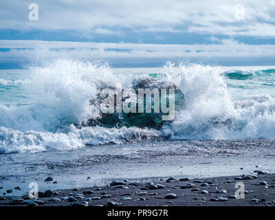 Choc des vagues d'océan à un iceberg sur la plage du Diamant en Islande Banque D'Images