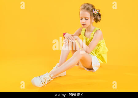 Portrait d'une fille en short blanc et jaune d'un sujet. Banque D'Images