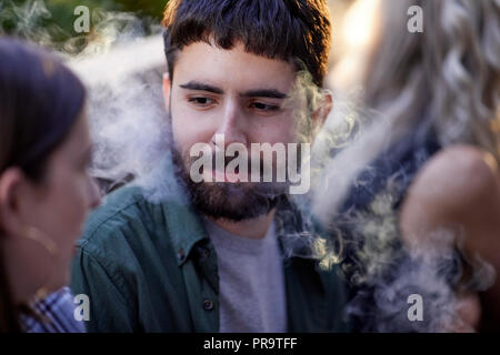 Les gens qui fument à l'aide de vape happing pens à Manchester Banque D'Images