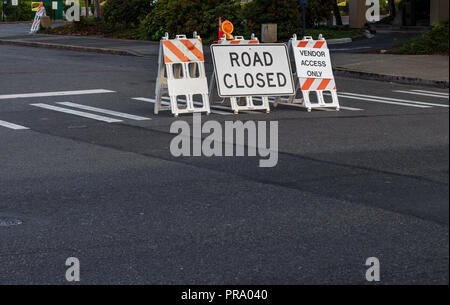 Route fermée signes et des barricades placées sur un passage pour piétons à une intersection Banque D'Images