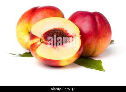 Trois nectarines avec des feuilles isolées sur fond blanc Banque D'Images