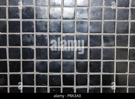 Carreaux de mosaïque noire sur un mur Banque D'Images