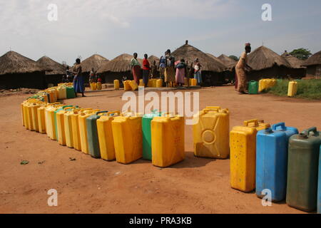 Une longue ligne de jerrycans d'attendre d'être comblé à un forage à l'eau unique Atiak déplacés internes (IDP) camp, Nord de l'Ouganda. Banque D'Images