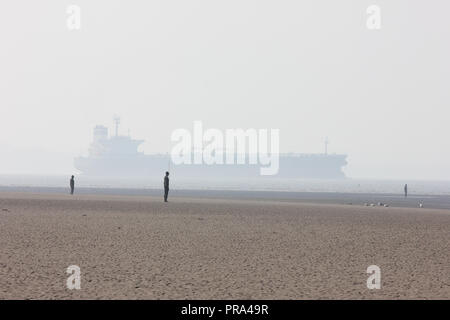 Un pétrolier sur l'estuaire de la Mersey passe Antony Gormley a un autre lieu à Crosby dans un léger brouillard Banque D'Images