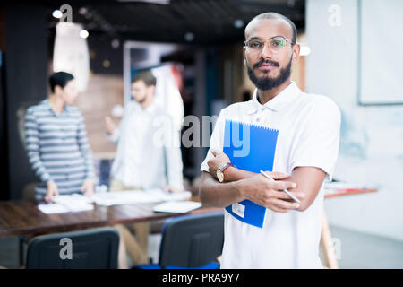 Serious mixed race student holding course Banque D'Images