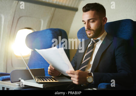 Handsome Businessman Working en avion Banque D'Images