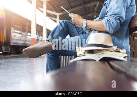 Voyageur asiatique homme avec effets personnels en attente de voyager par train à la gare de Chiang Mai, Thaïlande Banque D'Images