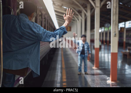 Voyageur asiatique homme avec effets personnels en attente de voyager par train à la gare de Chiang Mai, Thaïlande Banque D'Images