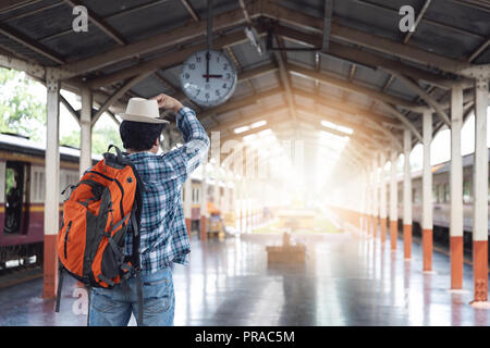 Voyageur asiatique homme avec effets personnels en attente de voyager par train à la gare de Chiang Mai, Thaïlande Banque D'Images