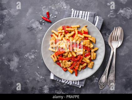 Des pâtes avec du poivre et du poulet en sauce tomate Banque D'Images