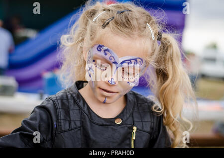 Adorable petite fille blonde avec la peinture du visage portrait Banque D'Images