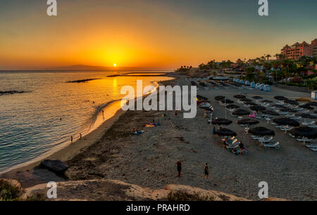 TENERIFE, ESPAGNE - 22 août : (NOTE DE LA RÉDACTION : l'image est un digital [gamme dynamique élevée, HDR] composite.) Le soleil se couche sur La Gomera derrière la Playa El Duque beach à Costa Adeje le 22 août 2018 à Tenerife, Espagne. Costa Adeje est l'une des destinations touristiques les plus populaires sur la côte sud de l'île. Banque D'Images