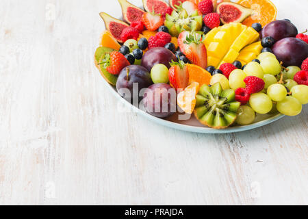 Les fruits sains et les baies, Fraises Framboises plaque Oranges Pommes Prunes Raisins kiwis mangues les bleuets, sur le tableau blanc woorden Banque D'Images