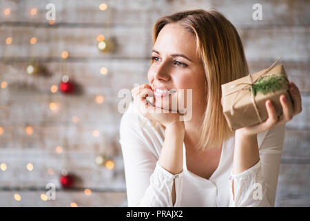 A young woman holding wrapped Christmas présents. Banque D'Images