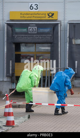 Pattensen, Allemagne. Le 01 octobre 2018. Les pompiers dans les scaphandres examiner une parcelle pendant une opération de matières dangereuses dans un colis et lettre centre de la Deutsche Post. Une fuite de liquide inconnu dans le centre de paquets a causé un incendie de grande ampleur l'opération de la brigade dans la matinée. Photo : Julian Stratenschulte/dpa dpa : Crédit photo alliance/Alamy Live News Banque D'Images