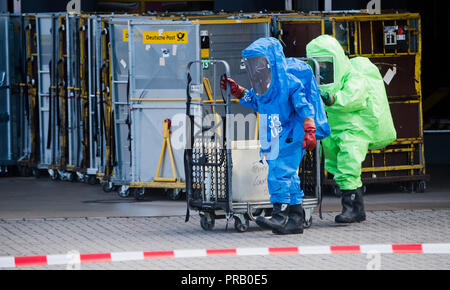 Pattensen, Allemagne. Le 01 octobre 2018. Les pompiers dans les scaphandres examiner une parcelle pendant une opération de matières dangereuses dans un colis et lettre centre de la Deutsche Post. Une fuite de liquide inconnu dans le centre de paquets a causé un incendie de grande ampleur l'opération de la brigade dans la matinée. Photo : Julian Stratenschulte/dpa dpa : Crédit photo alliance/Alamy Live News Banque D'Images