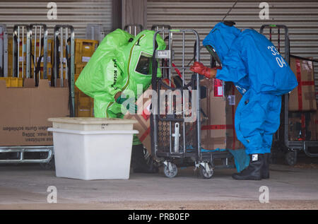 Pattensen, Allemagne. Le 01 octobre 2018. Les pompiers dans les scaphandres examiner une parcelle pendant une opération de matières dangereuses dans un colis et lettre centre de la Deutsche Post. Une fuite de liquide inconnu dans le centre de paquets a causé un incendie de grande ampleur l'opération de la brigade dans la matinée. Photo : Julian Stratenschulte/dpa dpa : Crédit photo alliance/Alamy Live News Banque D'Images