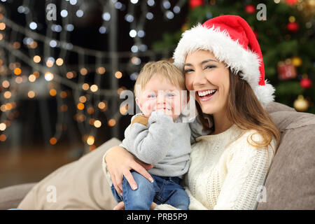 Happy mother and son à vous en posant dans Noël assis sur un canapé dans la salle de séjour à la maison Banque D'Images