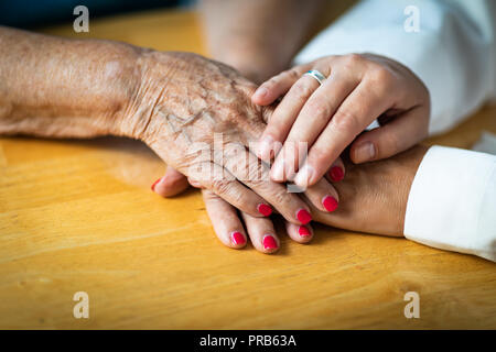 Jeune femme Hands Holding Senior Femme mains. Banque D'Images