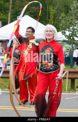 Une taille de l'équipe chinoise du tambour, vêtus de couleurs vives en costume traditionnel, fonctionne à un festival local. Banque D'Images