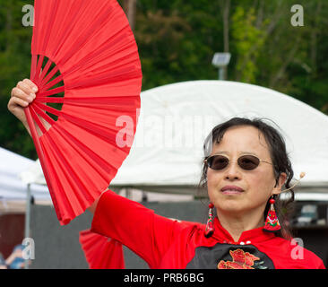 Une taille de l'équipe chinoise du tambour, vêtus de couleurs vives en costume traditionnel, fonctionne à un festival local. Banque D'Images