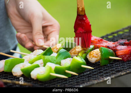 Brochettes de crevettes et poivrons au barbecue étant sur un grill extérieur. Banque D'Images