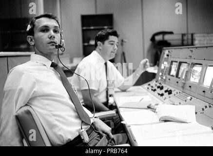 S68-50696 (octobre 1968) --- Bureau des affaires publiques (OAP) commentateur Douglas K. Ward (premier plan) est photographié à sa console dans la salle de contrôle des opérations de Mission (MOCR) dans le centre de contrôle de mission au Centre spatial Johnson de la NASA pendant le vol d'Apollo 7. Crédit photo : NASA Banque D'Images