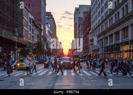 NEW YORK - 7 juin 2018 : l'intersection de la 23e Rue et Broadway est encombrée de gens et de voitures alors que le soleil se couche entre les bâtiments Banque D'Images