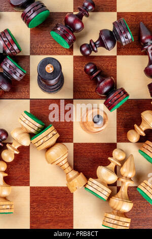 Une photo prise à la verticale d'une situation d'échecs en échec et mat avec presque tous les morceaux tombés sur l'échiquier Banque D'Images