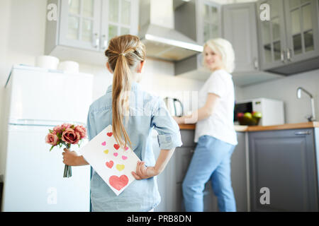 Petite fille se cacher derrière le dos de carte fait main tout en bouquet de roses pour maman Banque D'Images