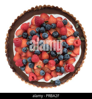 Tarte au chocolat végan avec croûte d'amandes et la crème de coco aux fruits rouges et graines de citrouille topping isolé sur fond blanc, vue du dessus Banque D'Images